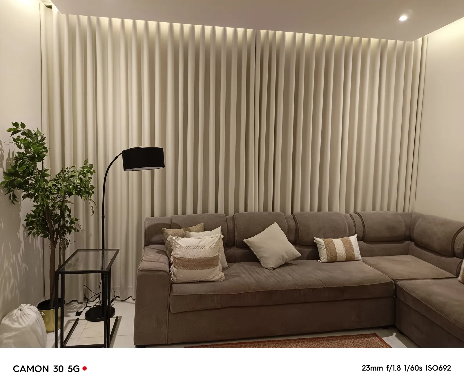 Floor-to-ceiling sheer curtains beside a corner sofa in a Dammam villa living room