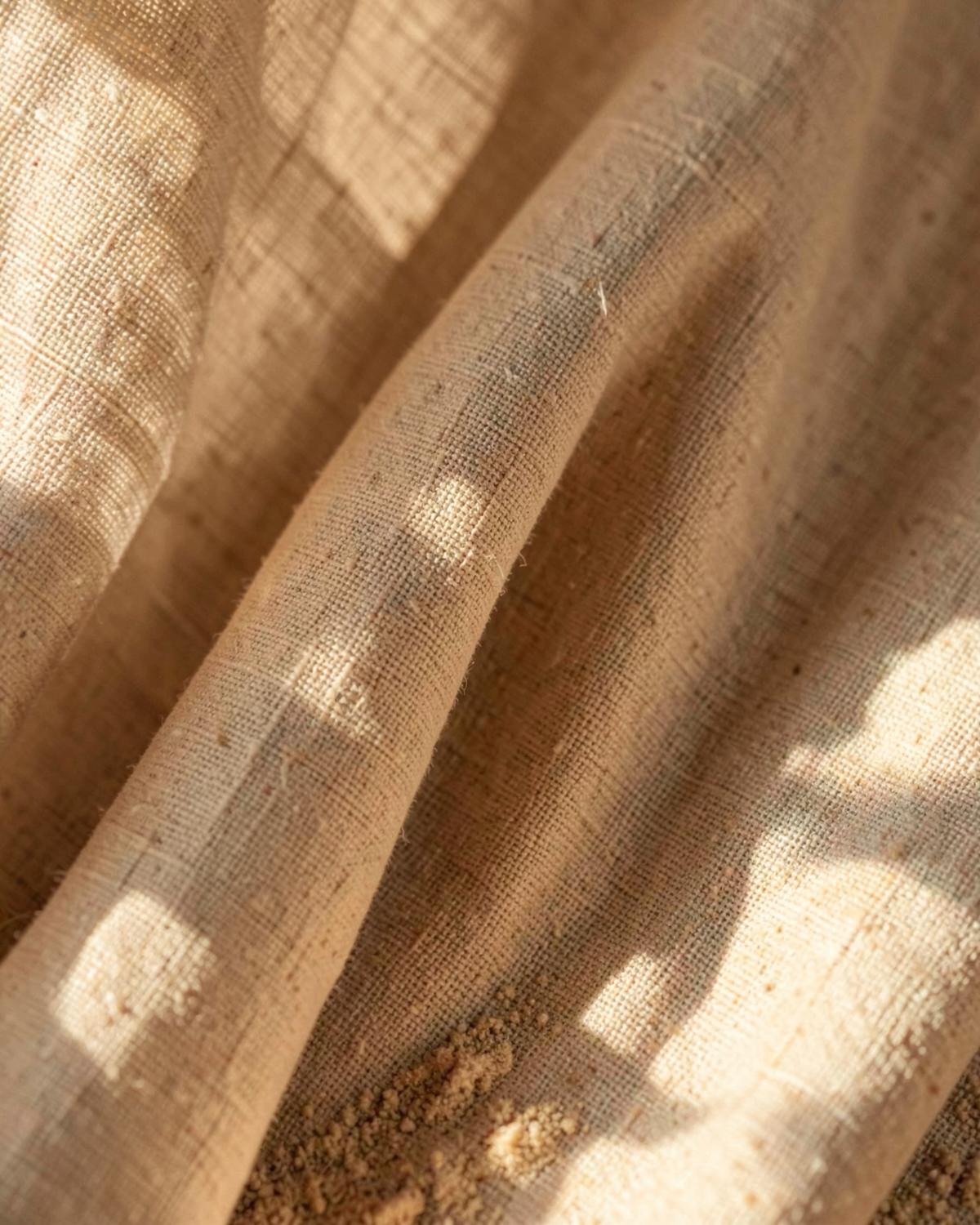 Close-up of natural sand-toned linen curtain fabric